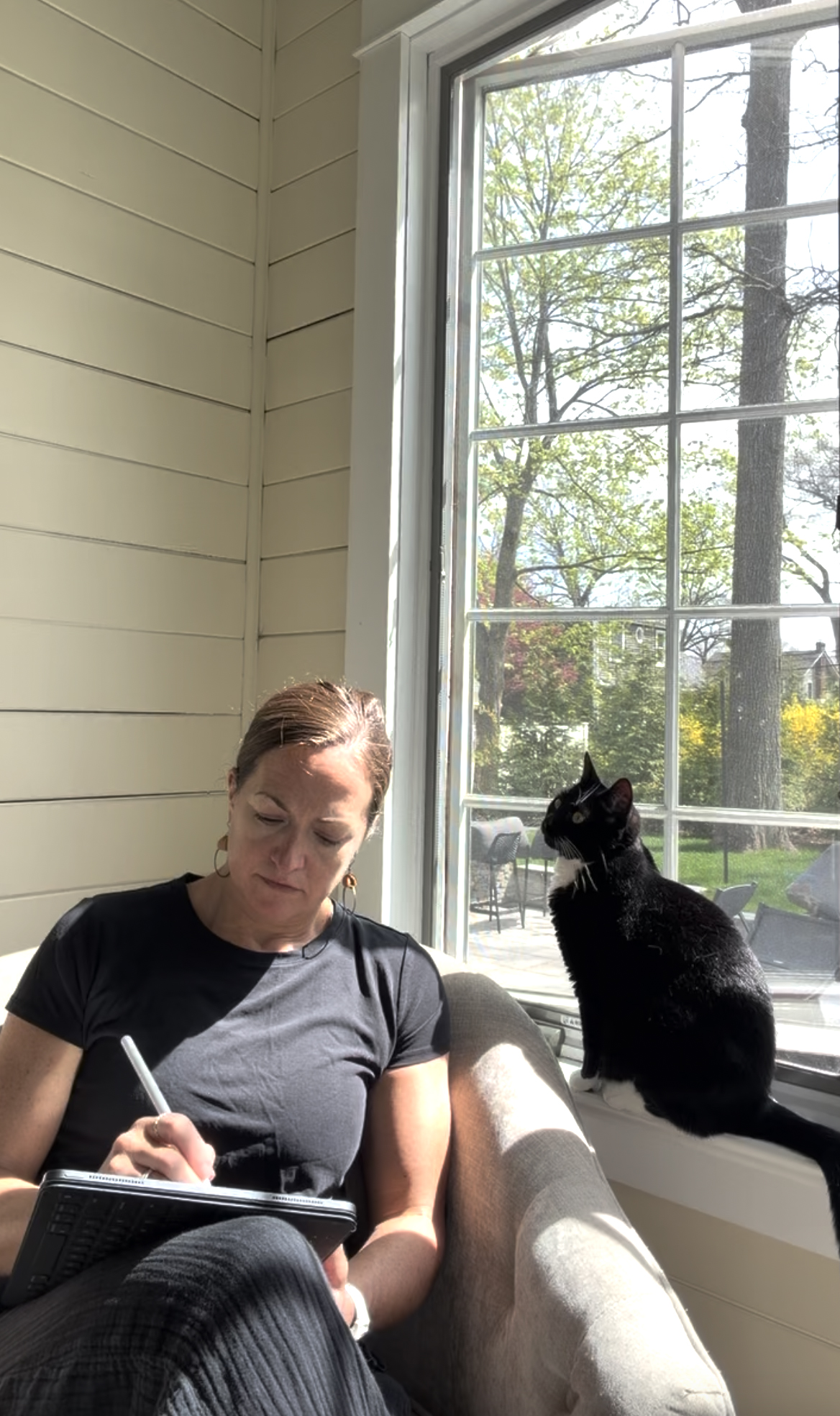 Michele drawing on her iPad with her cat Julie watching